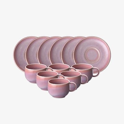 Rosa Kaffeeservice mit sechs Untertassen und sechs Tassen in zwei Reihen vor weißem Hintergrund