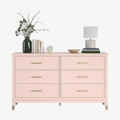 Rosa Kommode mit sechs Schubladen, dekoriert mit Vase, Büchern, Schale, Kugelobjekt und Tischlampe