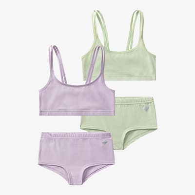 Zwei Sets Mädchenunterwäsche in Pastellfarben – ein Set in Flieder, ein Set in Hellgrün – jeweils mit Top und Slip