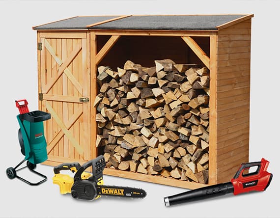 Holzschuppen mit gestapeltem Brennholz, Gartenhäcksler, gelbe Kettensäge und roter Laubbläser davor