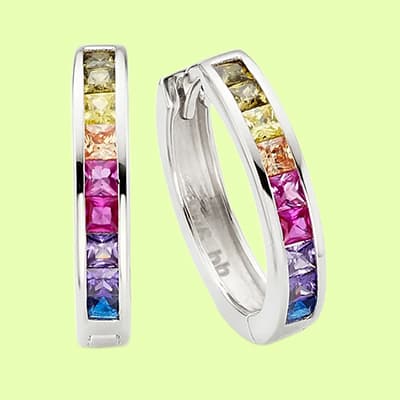 Zwei silberne Ohrringe mit bunten Edelsteinen auf gelbem Hintergrund.