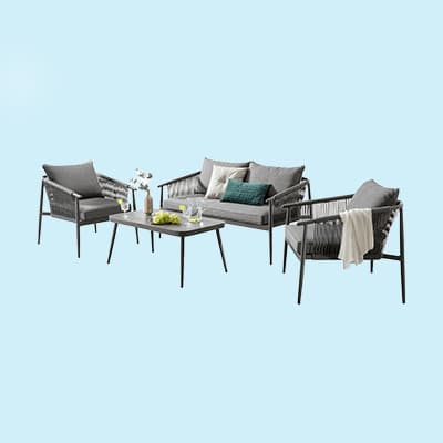Gartenmöbel-Set mit Sofa, zwei Sesseln und Tisch, dekoriert mit Kissen und Pflanzen.