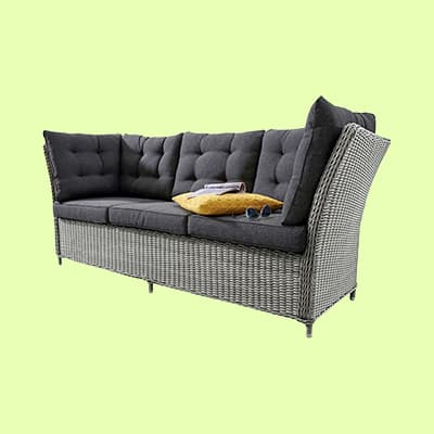 Graues Sofa mit Kissen, Brille und Buch auf heller Hintergrundfläche