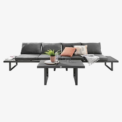 Outdoor-Sofa mit dunklen Kissen und Tisch mit Pflanzen und Getränken