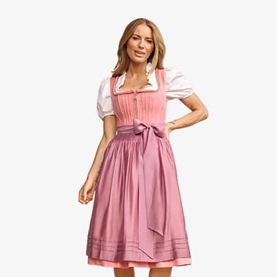 Frau im knielangen, rosa Dirndl mit Spitzenschürze und Schleife, steht seitlich vor weißem Hintergrund