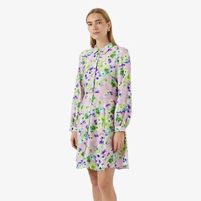Frau im knielangen Hemdblusenkleid mit langem Arm und buntem Blumenmuster in Rosa, Grün und Lila