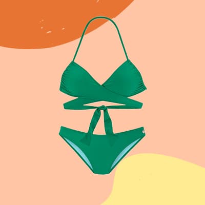 Grüner Bikini mit Wickeloberteil und Bindeschleife, vor buntem Hintergrund in Orange, Rosa und Gelb schwebend dargestellt